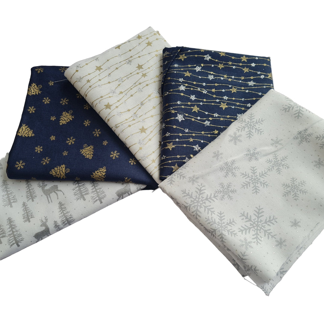 Five fabric fat quarters in navy and white with Christmas winter-themed patterns